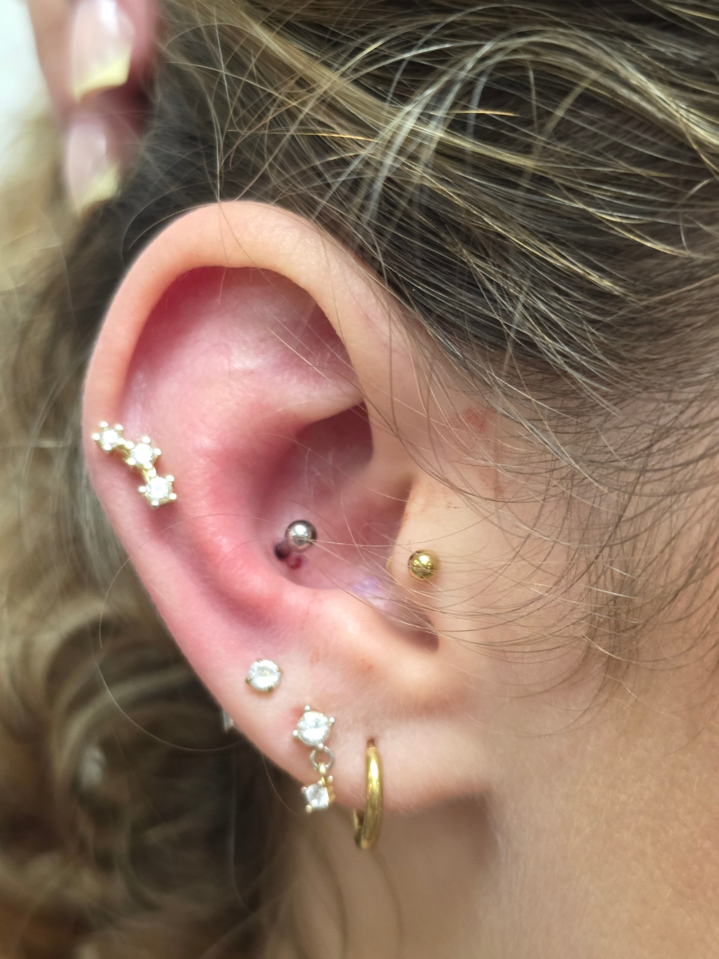 Conch ear piercing with gold and crystal jewellery