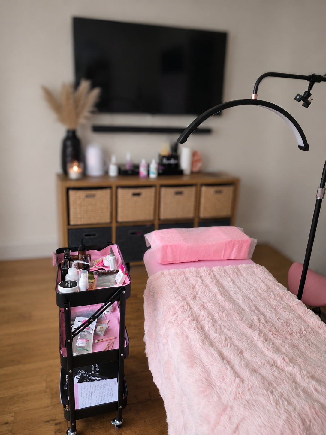 Beauty treatment room with pink furnishings and professional lash supplies